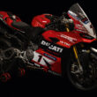 motoocicleta ducati rosie cu stikere pe fundal negru