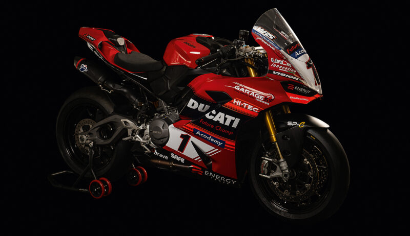 motoocicleta ducati rosie cu stikere pe fundal negru