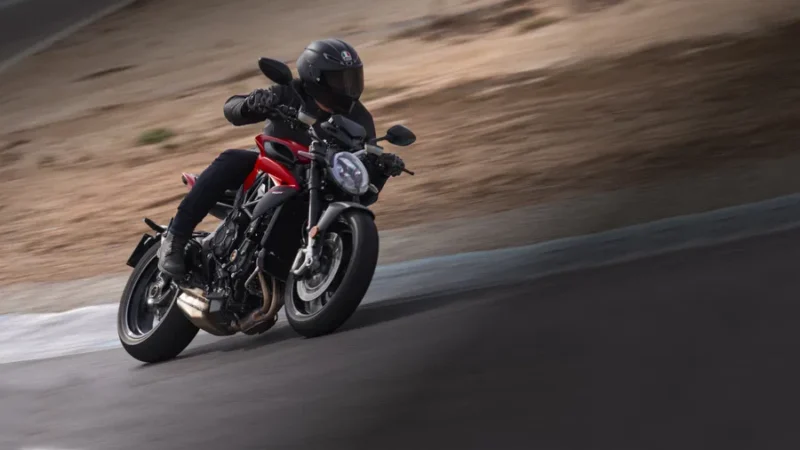 motocicleta naked inclinata pe partea dreapta pe circuit de culoare rosie