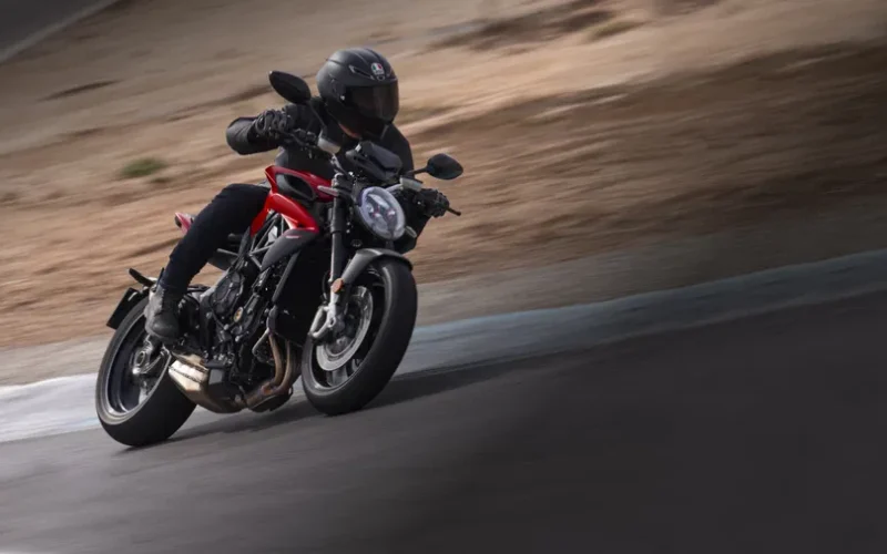 motocicleta naked inclinata pe partea dreapta pe circuit de culoare rosie