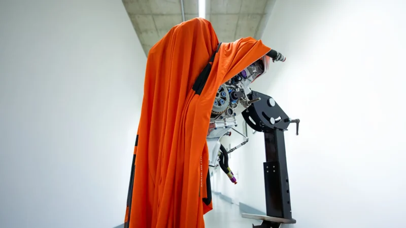 motor acoperit cu o pelerina portocalie intr-un stand