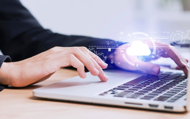 ilustratie cu o femeie care foloseste un serviciu de stocare in cloud pe un laptop