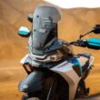 botul unei motociclete enduro fotografiata cu un munte in spate