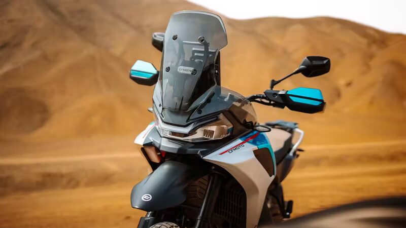 botul unei motociclete enduro fotografiata cu un munte in spate