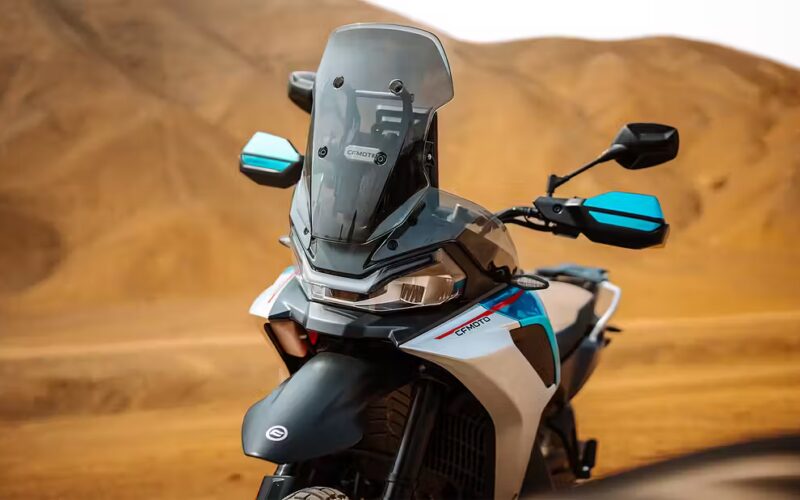 botul unei motociclete enduro fotografiata cu un munte in spate