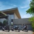 trei motociclete retro fotografiate in fata unei case moderne