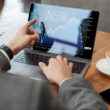 un investitor priveste un grafic pe ecranul unui laptop