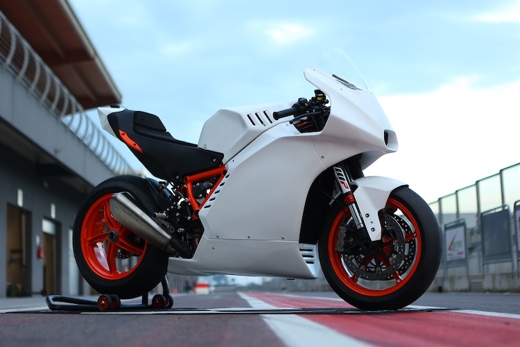 motocicleta alba de circuit fotografiata la bozele unui circuit moto