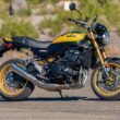 motocicleta galbena retro cu o padure in fundal