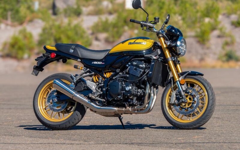 motocicleta galbena retro cu o padure in fundal