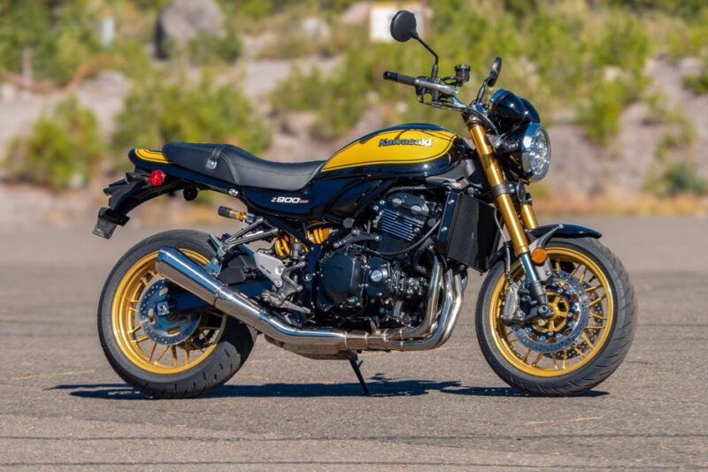 motocicleta galbena retro cu o padure in fundal