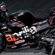 motocicleta aprilia de culoare neagra pe stander pe fond negru