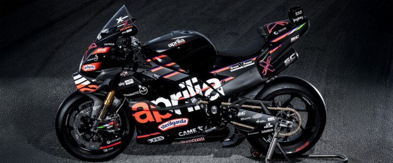 motocicleta aprilia de culoare neagra pe stander pe fond negru