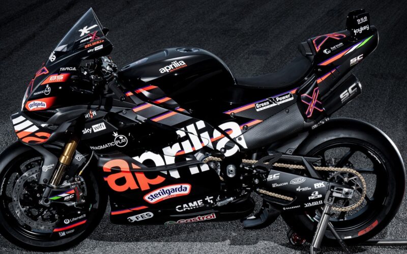 motocicleta aprilia de culoare neagra pe stander pe fond negru