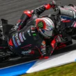 pilot motogp fotografiat inclinat extrem pe partea dreapta pe ciruit de mare viteza