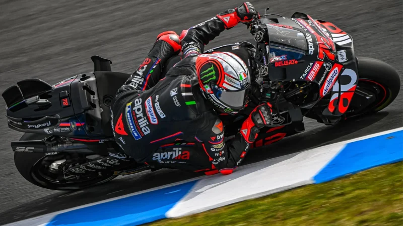 pilot motogp fotografiat inclinat extrem pe partea dreapta pe ciruit de mare viteza