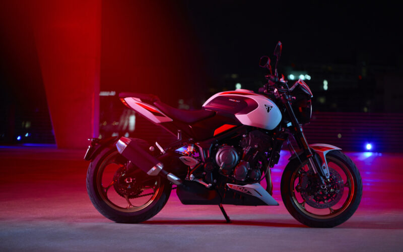 motocicleta triumph trident 800 in mediu urban cu fundal rosu