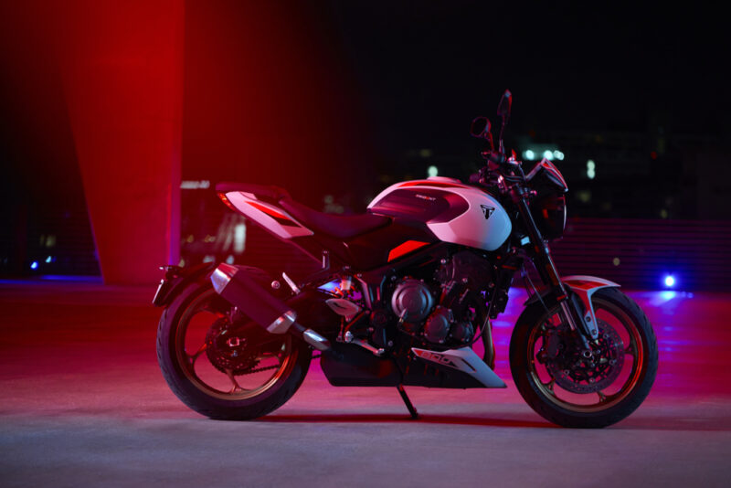 motocicleta triumph trident 800 in mediu urban cu fundal rosu