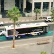 o imagine cu un autobuz care merge pe un sector de autostrada cu posibilitate de incarcare a masinilor electrice