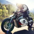 concept motocicleta futurista de la bmw suprinsa pe un drum de munte intre copaci