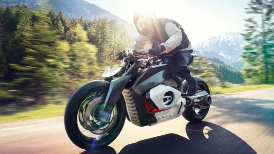concept motocicleta futurista de la bmw suprinsa pe un drum de munte intre copaci