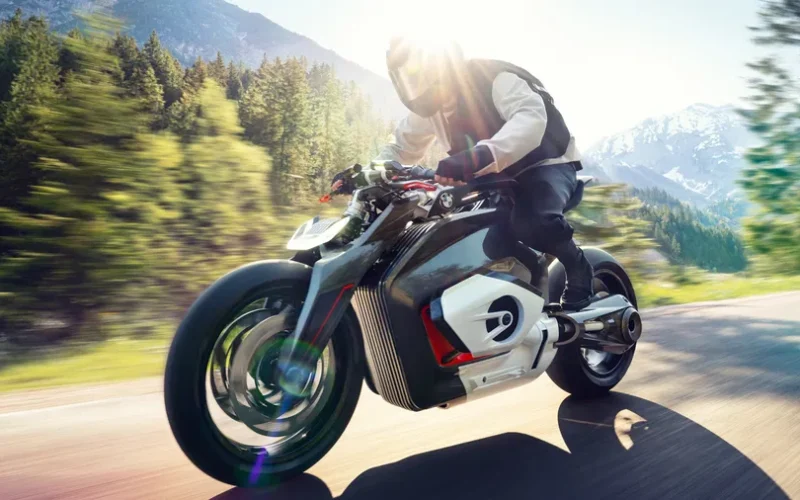 concept motocicleta futurista de la bmw suprinsa pe un drum de munte intre copaci