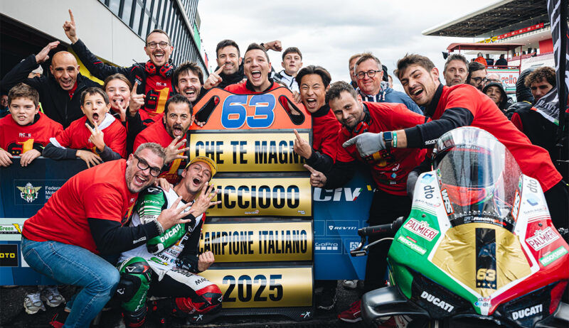 grup de persoane ce se bucura de castigarea uui premiu pe un circuit moto