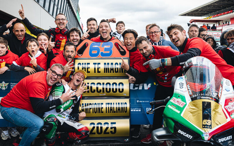grup de persoane ce se bucura de castigarea uui premiu pe un circuit moto