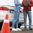 o tanara si instructorul sau auto pe un poligon