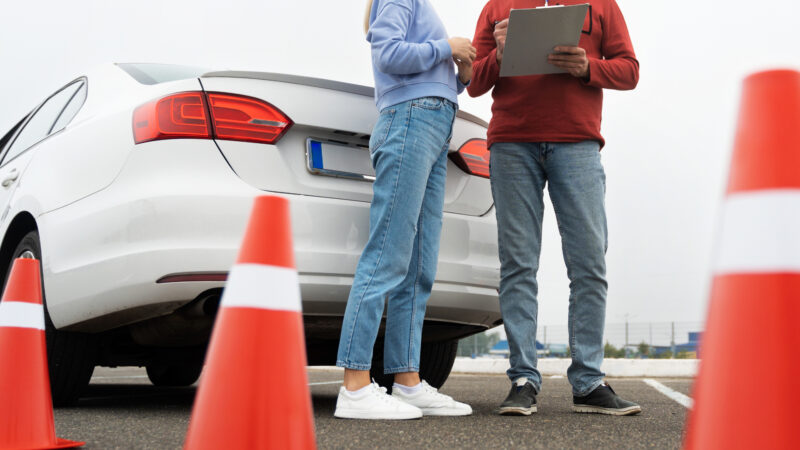 o tanara si instructorul sau auto pe un poligon