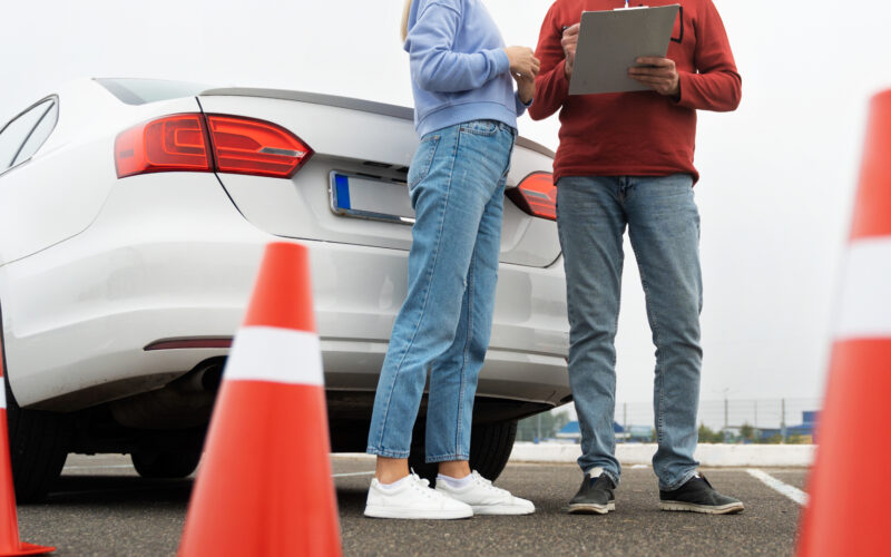 o tanara si instructorul sau auto pe un poligon