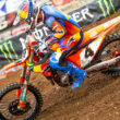 motociclist de adventure surprins pe circuit de competitie off-road pe o motocicleta portocalie