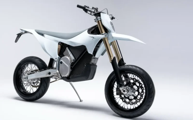 motocicleta electrica de culoare alba si tip super moto pe fundal gri