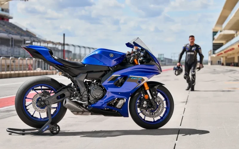 motocicleta super sport de culoare albastra pe circuit cu rider in fundal