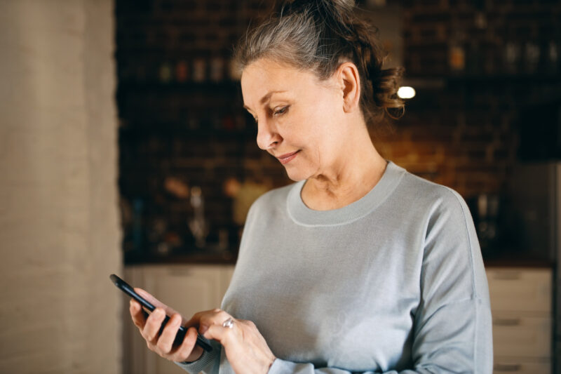 o femeie mai in varsta foloseste un telefon