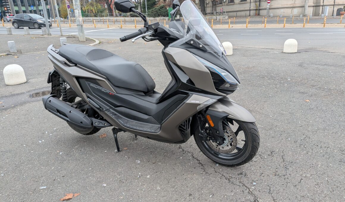 maxi scuter de culoare gri in mediul urban