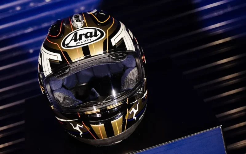 casca moto Arai de culoare aurie pe fuundal albastru