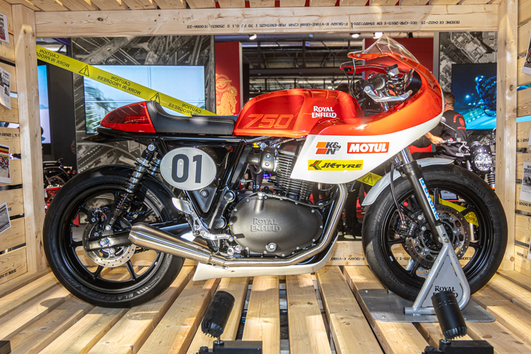 motocicleta clasica de culoare portocalie pe stand de prezentare