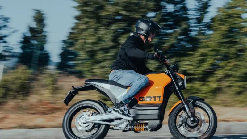 motocicleta galbena electrica cu o padure in fundal