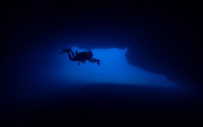 Scafandru care explorează structuri de pe fundul mării