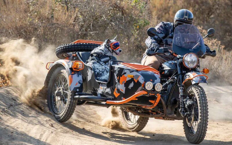 motocicleta cu atas de culoare neagru cu dungi portocalii in teren accidentat