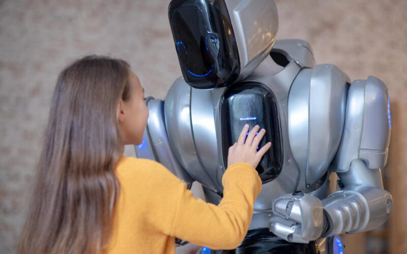 o fetita interactioneaza cu un robot inzestrat cu ai